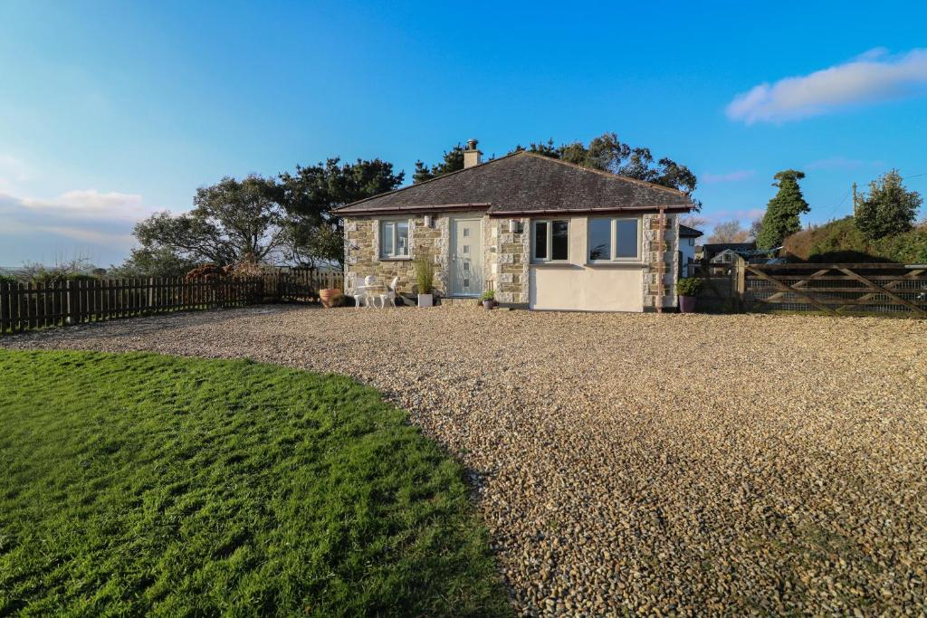 a stone house with a fence and a gravel driveway at Valley View in St Austell