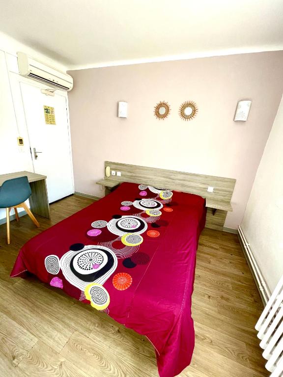 a red bed with plates of food on it at Hôtel Colisée-Verdun Centre Gare Saint-Roch in Montpellier