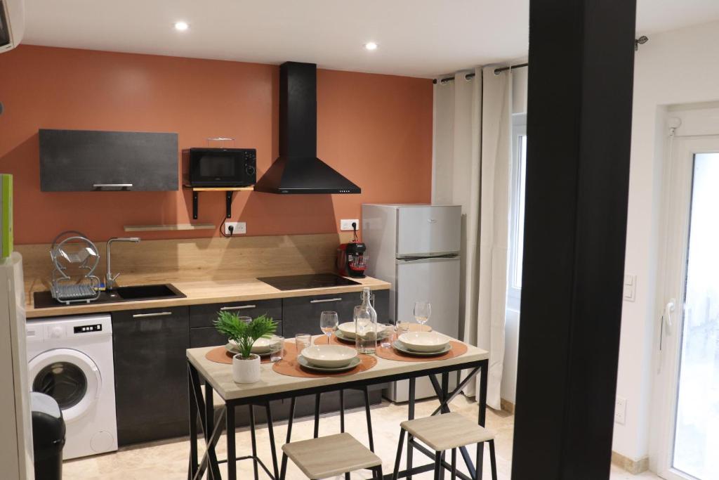uma cozinha com uma mesa com cadeiras e um fogão em Superbes Appartements Modernes et Neufs em Bagnols-sur-Cèze