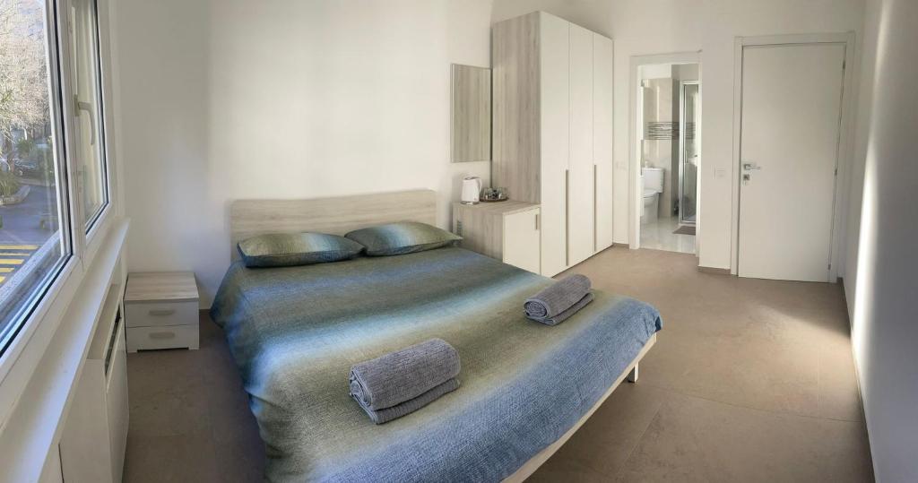 a bedroom with a bed with two pillows on it at *Veranda's rooms* - Free parking in central Lugano in Lugano