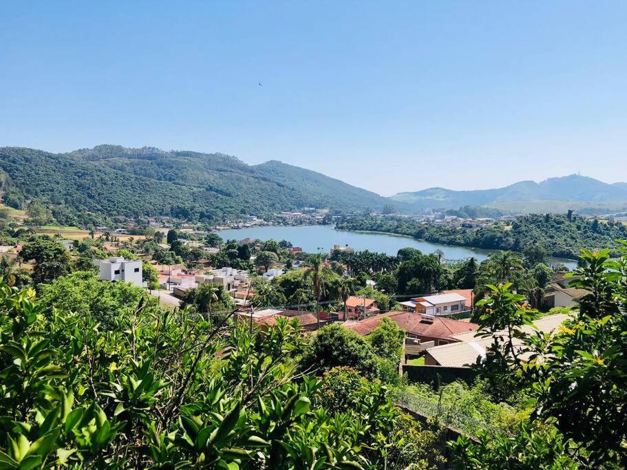 a view of a town with a lake and mountains at Casa para temporada, represa Bortolan Poços de Caldas in Poços de Caldas