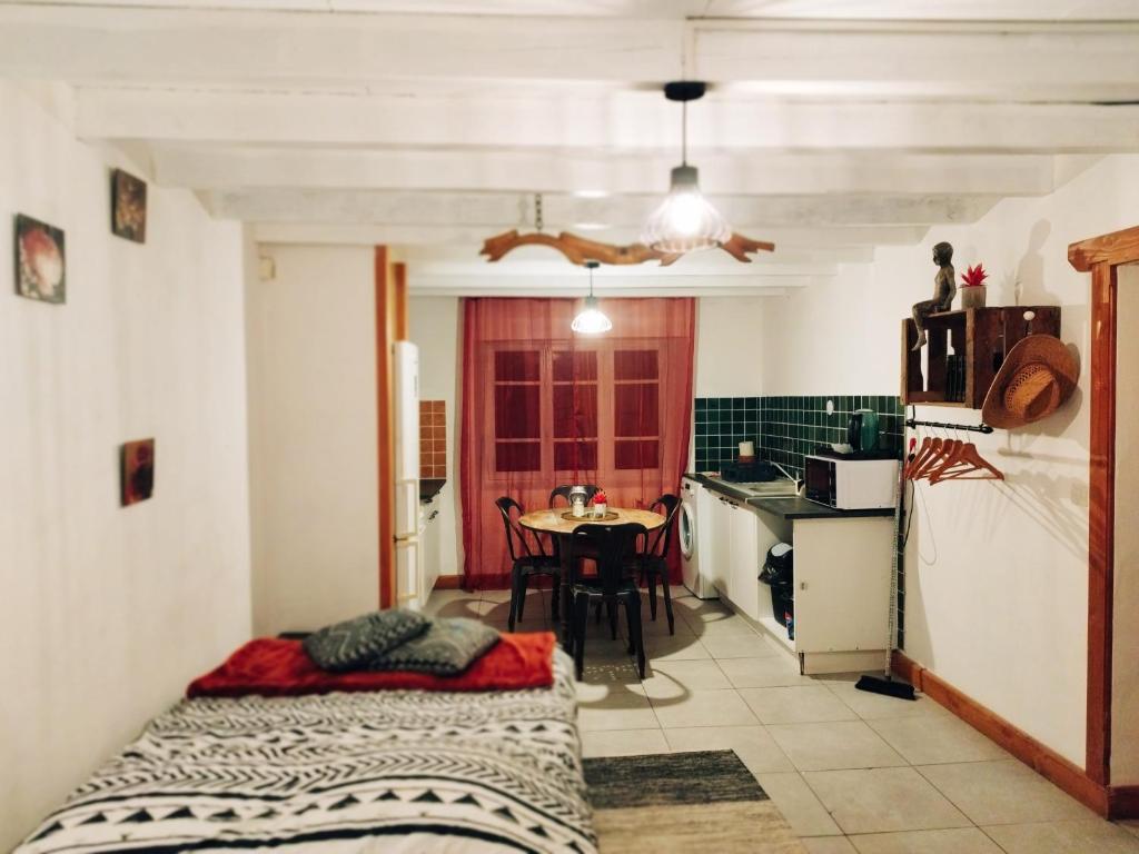 um quarto com uma cozinha e uma mesa em Charmant studio tout équipé em Olliergues