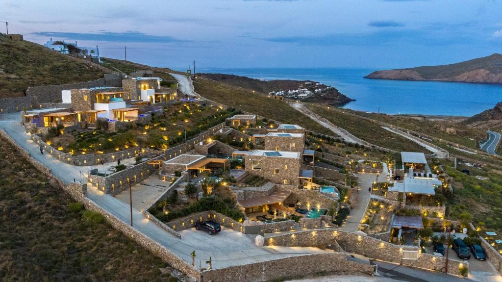 an aerial view of a building on a hill with the ocean at The Mykonist Panormos Exclusive Suites & Villas in Panormos Mykonos