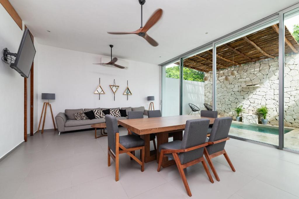 una sala da pranzo con tavolo e sedie in legno di Relaxing 2 bedroom apartement in the center of tulum with private pool and terrace a Tulum