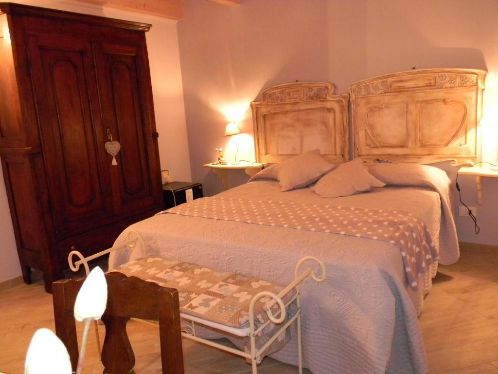 a bedroom with a large bed with a wooden headboard at B&B Il Cotogno in Gavi