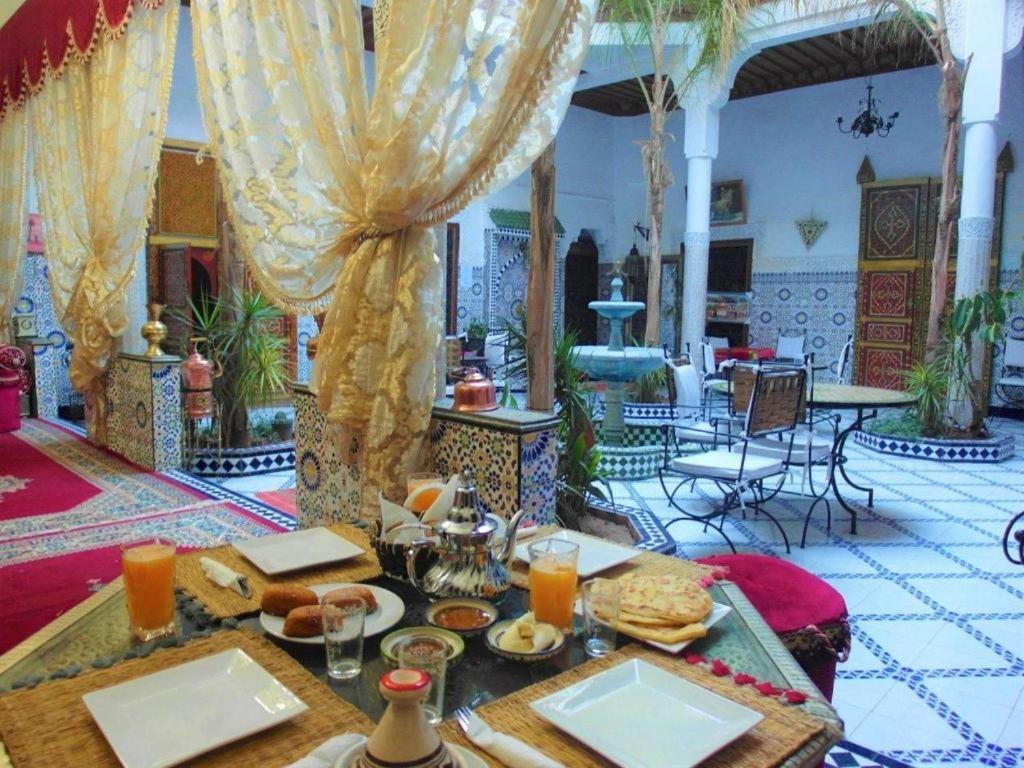 Riad Osawa في مراكش: غرفة طعام مع طاولة عليها طعام