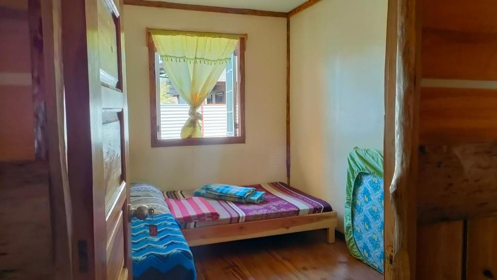 a small room with a small bed and a window at Acai's Transient House in Sagada