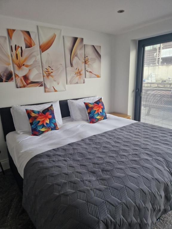 um quarto com uma cama grande e pinturas na parede em Posyrooms em Manchester