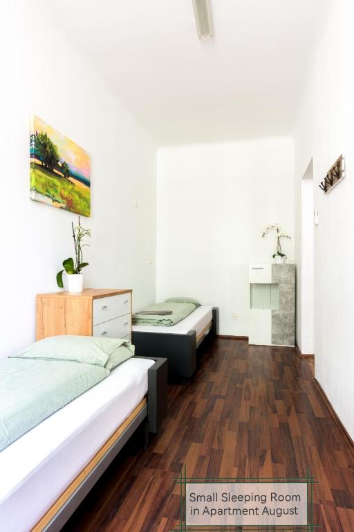 two beds in a room with wooden floors at 7brunnen Hostel Beds & Rooms in Vienna