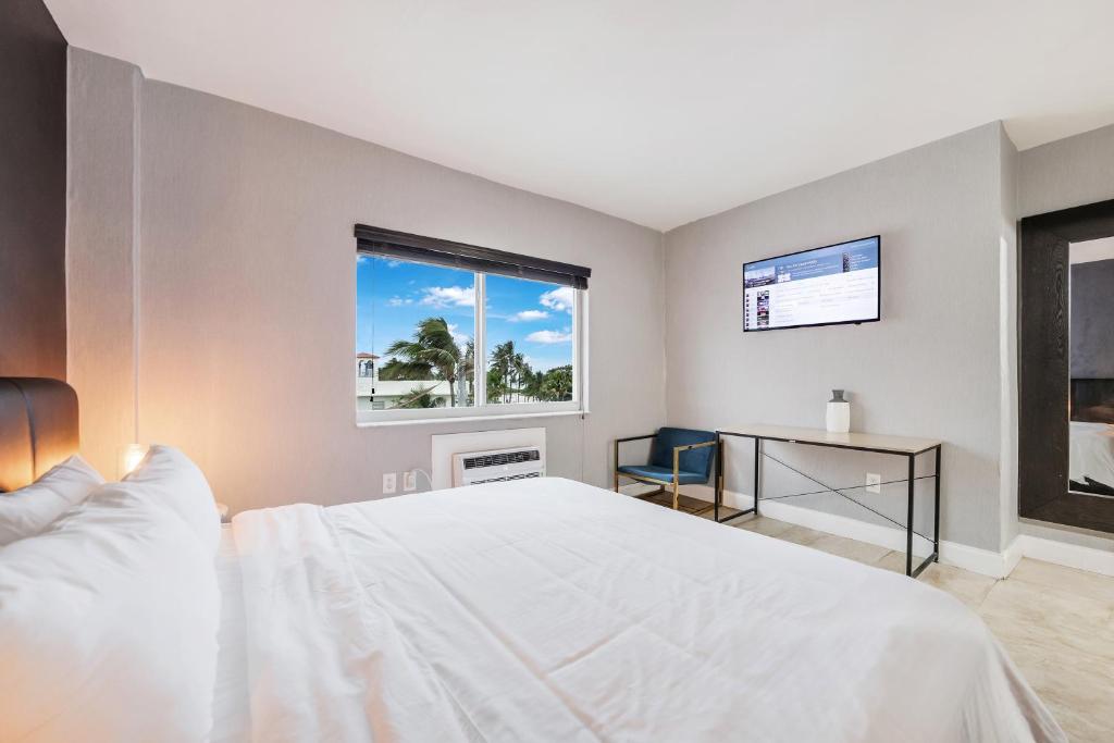 1 dormitorio con cama blanca y ventana en Starlite Hotel, en Miami Beach