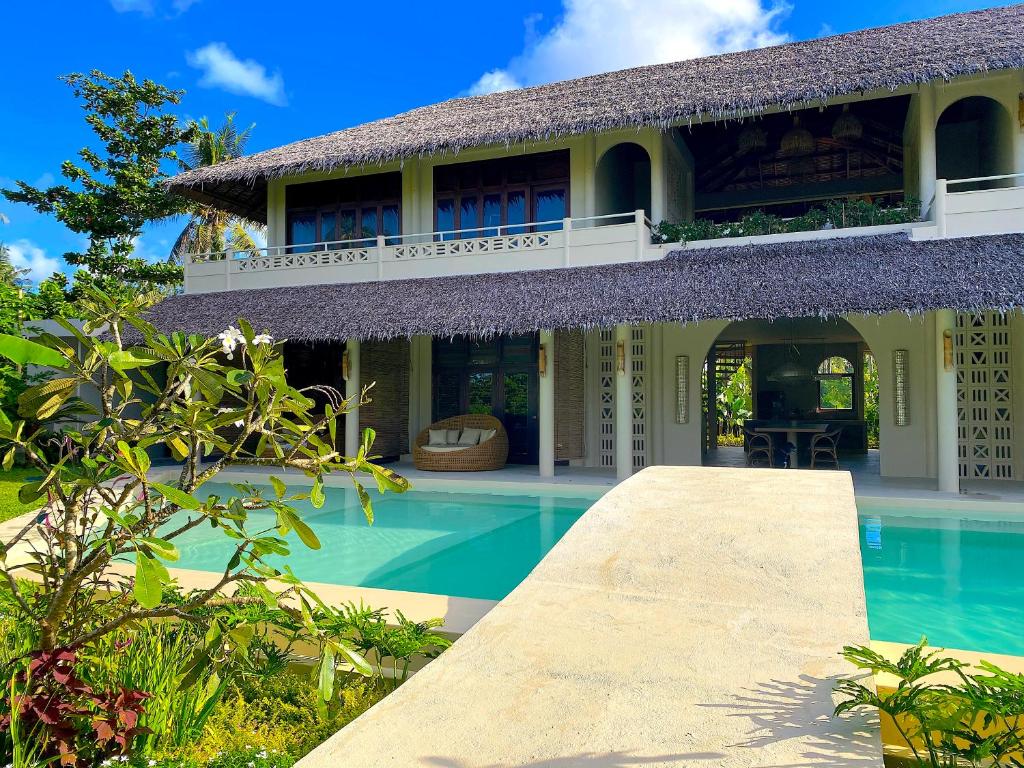 una casa con piscina frente a ella en Schönhouse Villa Siargao, en General Luna