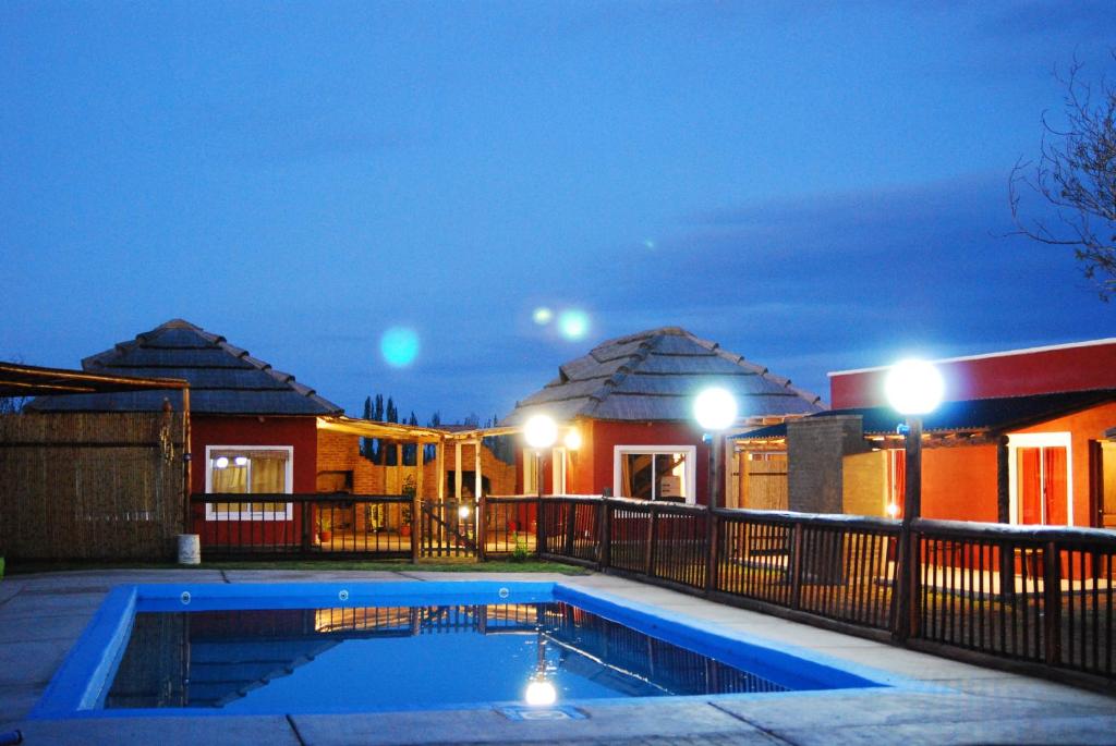 a house with a swimming pool at night at La Aldea in San Rafael