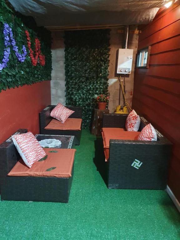 Zimmer mit 3 Sofas und grünem Teppich in der Unterkunft Casa en Peñuelas in Coquimbo