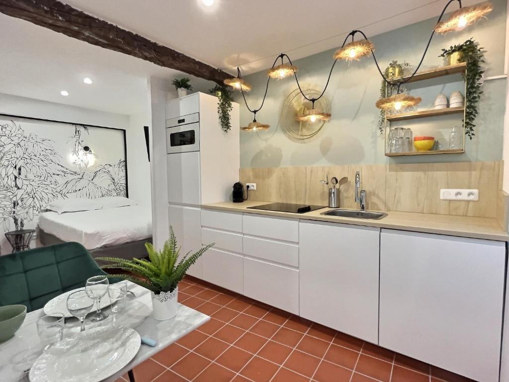 a kitchen with white cabinets and a sink and a bed at La trilogie de Pagnol by K6 in Aubagne