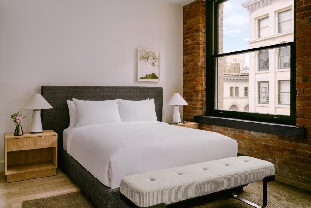 ein Schlafzimmer mit einem großen weißen Bett und einem Fenster in der Unterkunft Sonder Apollon in Montreal