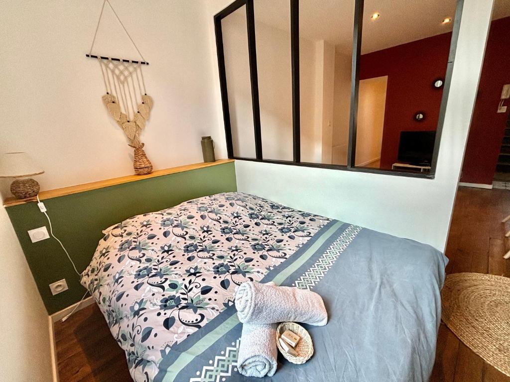 een slaapkamer met een bed met handdoeken en een spiegel bij Moulins: Superbe appartement centre ville in Moulins