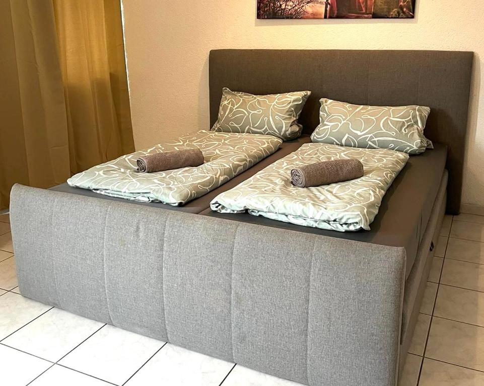 a couch with two pillows on top of it at nJoy! EXPO Studio & Zentral - Stuttgart Flughafen & Messe - perfekt für Work & Travel in Filderstadt