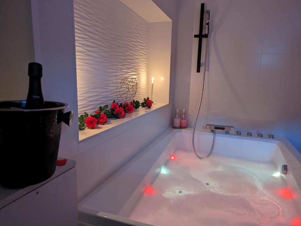 Villeneuve-de-la-Raho的住宿－Splendide Suite LOVE ROOM avec JACUZZI PRIVATIF，白色浴室内的红灯浴缸