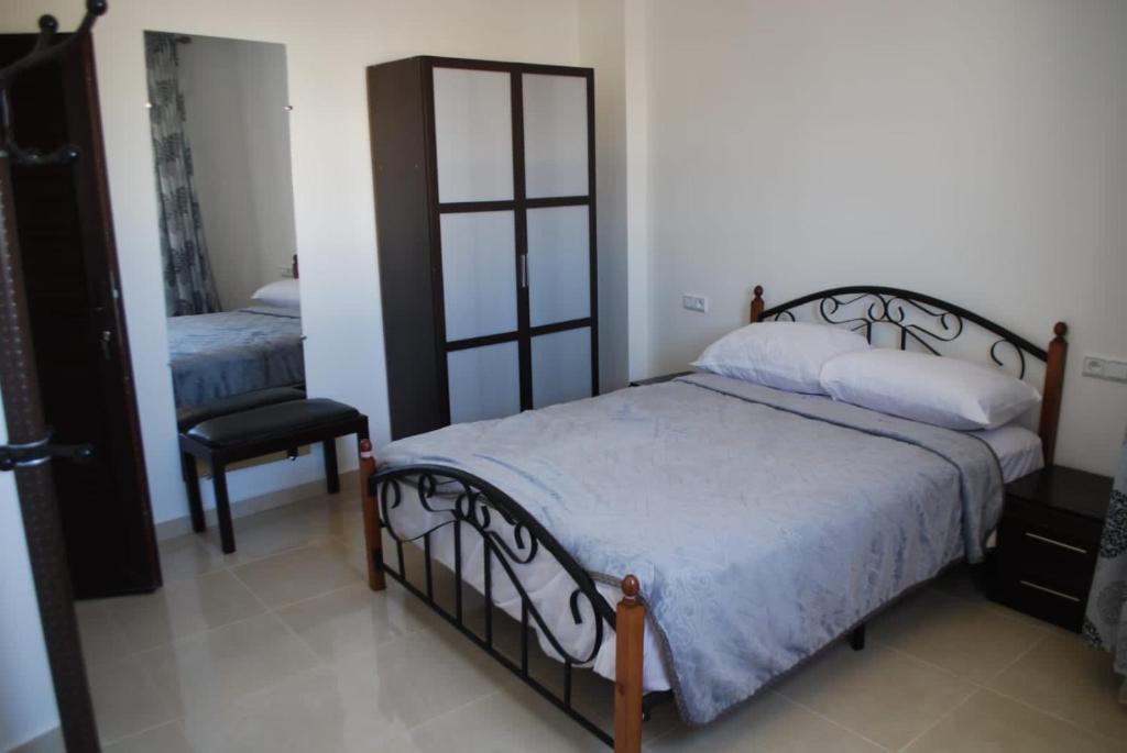 a bedroom with a bed and a mirror and a chair at Apartamentos Bchraya in Laayoune