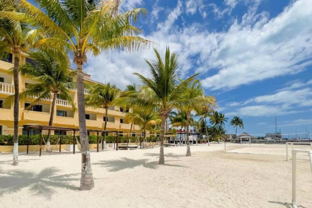 una fila de palmeras frente a un edificio en Apartamento en complejo hotelero con playa, en Cancún