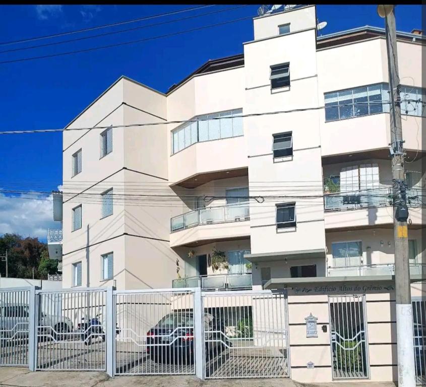 un edificio blanco con una valla delante en Aconchego, en São Roque