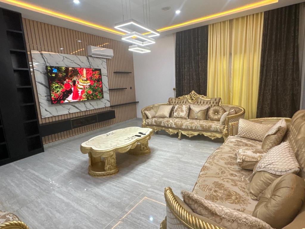 a living room with two couches and a tv at Luxury Villa within Abuja Sanctuary in Abuja