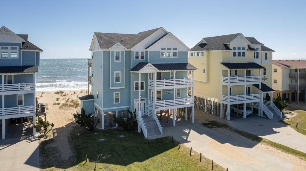 an aerial view of three houses on the beach at Cape Point Retreat 7 Bedroom Home by KEES Vacations in Buxton