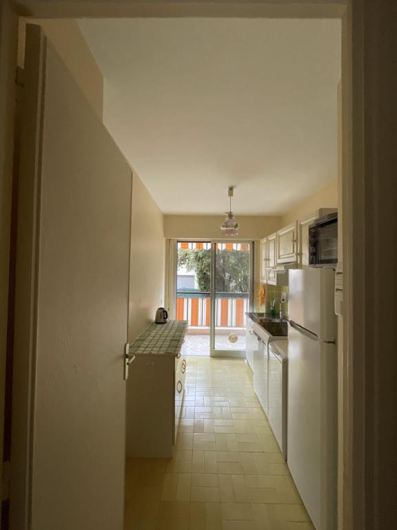 a kitchen with a white refrigerator and a window at GuestRoom - Chambre d'hôte in Le Cannet