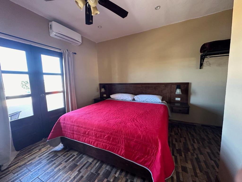 1 dormitorio con cama roja y ventana en Chulavista Loreto, en Loreto