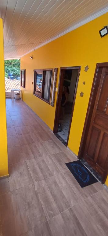 una habitación con una pared amarilla y una puerta en Casa Gaúcho en Morro de São Paulo