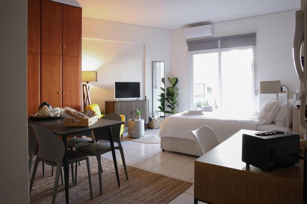 a living room with a bed and a room with a table at Happy Place Home # 1 in Volos