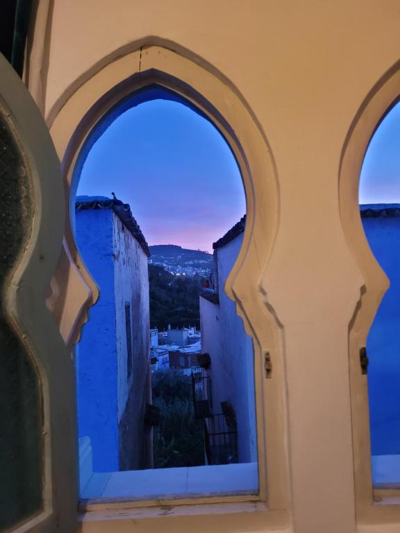 an arched window with a view of a city at Honey Suckle in Chefchaouene