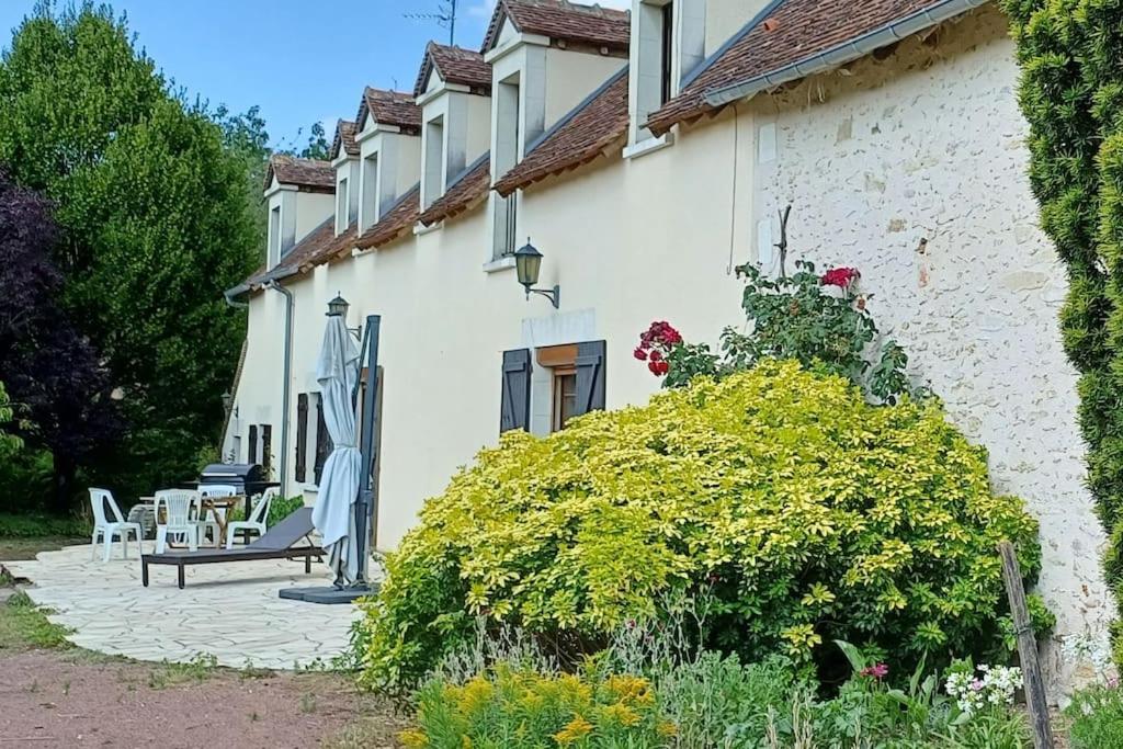 une maison blanche avec un banc et une table dans l'établissement Maison familiale (10p) à 15 min du Zoo de Beauval, à La Vernelle