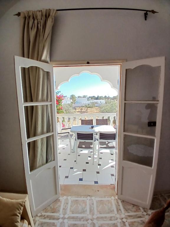 an open door to a dining room with a table at Menzel Churasco Djerba in Aghīr