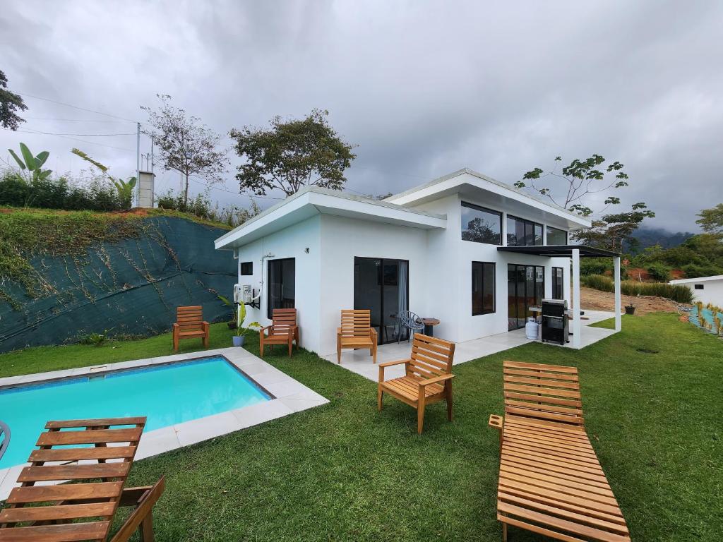 Casa blanca con piscina y sillas en Canavida Villas & Resort, en Uvita