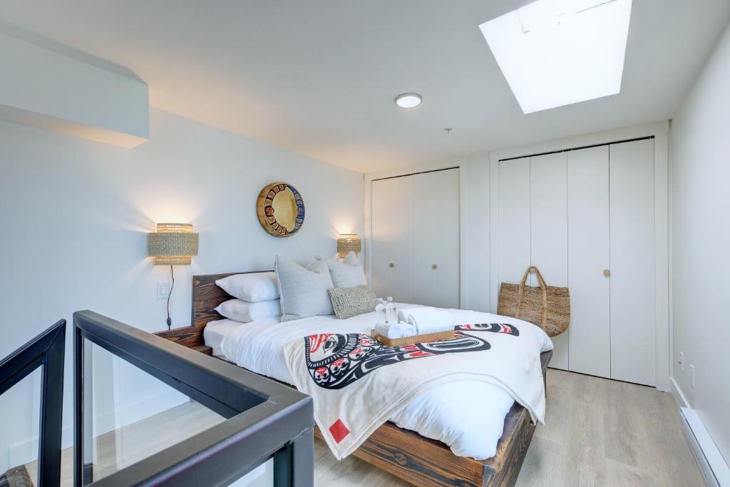 ein Schlafzimmer mit einem Bett und einer Uhr an der Wand in der Unterkunft West Coast Loft with Rooftop Patio + Harbour View in Victoria
