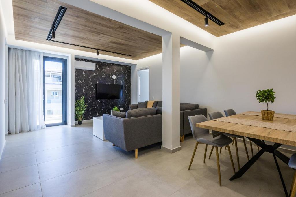a living room with a table and a dining room at Varkiza Luxury Suites by Raise in Vari