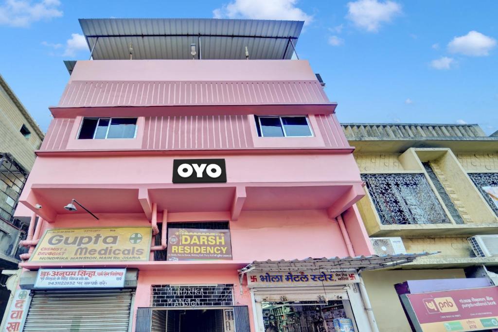 Un edificio rosa con un letrero de oxo. en OYO Flagship Darsh Residency, en Dhanbād