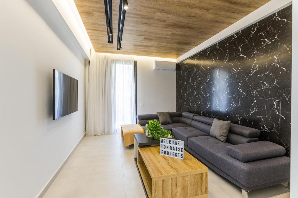 a living room with a couch and a table at Varkiza Luxury Suites by Raise in Vari