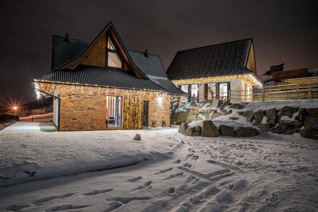 Una casa en la nieve por la noche en TATRZAŃSKIE TARASY Luxury Chalets, en Małe Ciche