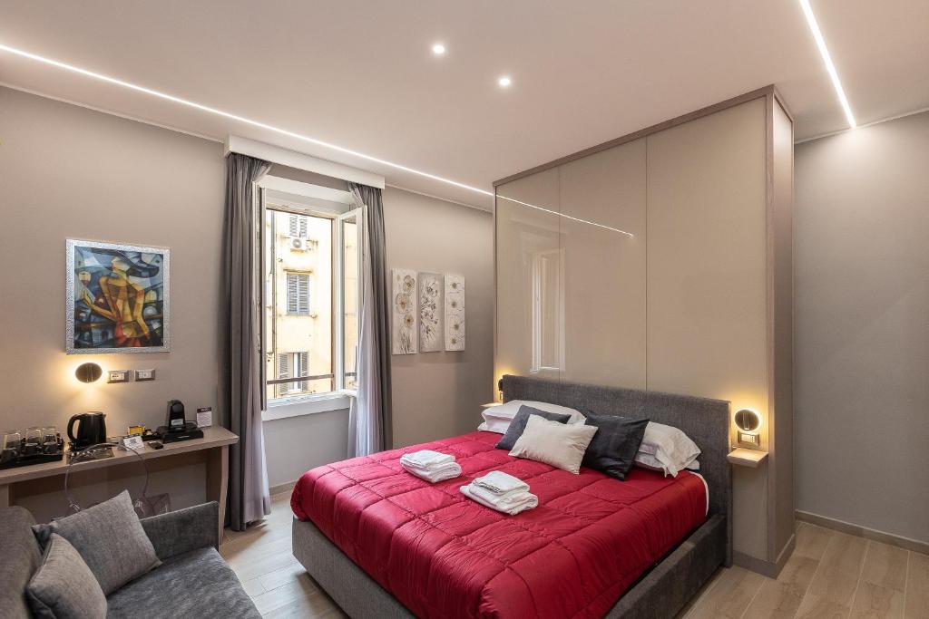 a bedroom with a red bed with a red blanket at IRON Luxury Rooms in Rome