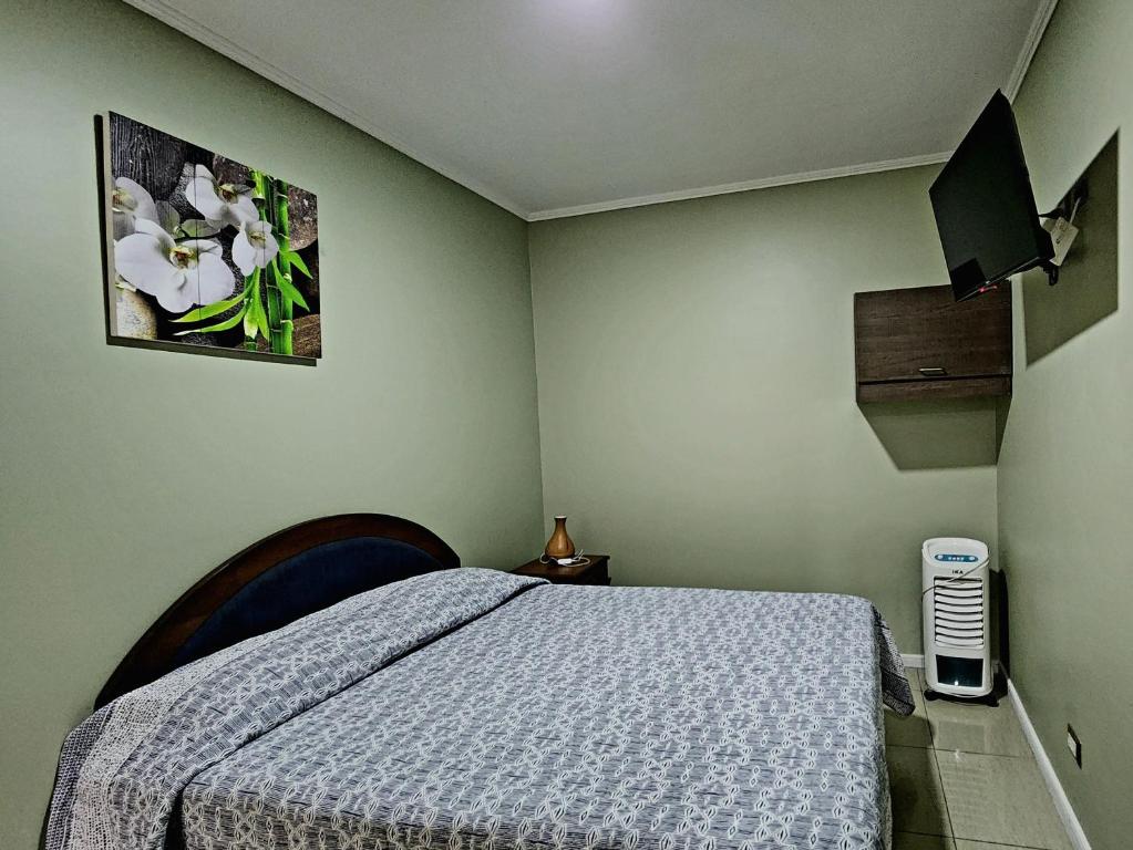 1 dormitorio con 1 cama con edredón azul en Hostal Ostello Amadeus, en Arica