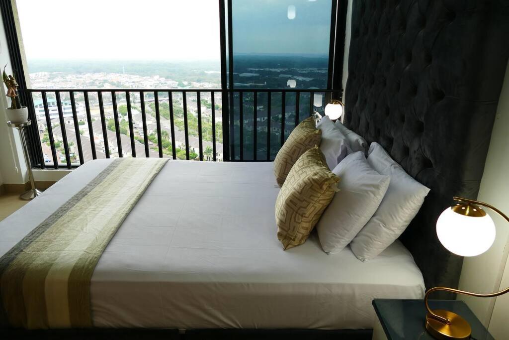 a bed with pillows and a balcony with a view at Ecusuites Penthouse Vía Costa Ceibos Puerto Azul in Guayaquil