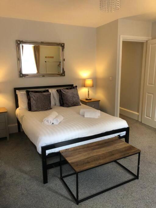 a bedroom with a bed with a mirror and a table at The Stuart Suite - spacious, affordable, city centre in York