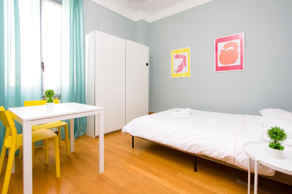 een slaapkamer met een bed, een bureau en een tafel bij Minimal Design in Milano in Milaan