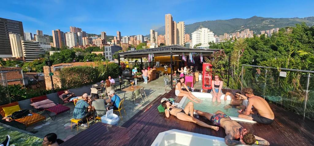 麥德林的住宿－Viajero Medellin Hostel，一群人坐在游泳池周围