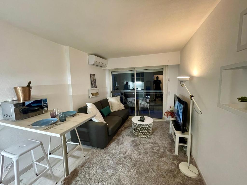 un salon avec un canapé et une table dans l'établissement NICE Hollydays, Studio St Antoine, à Nice