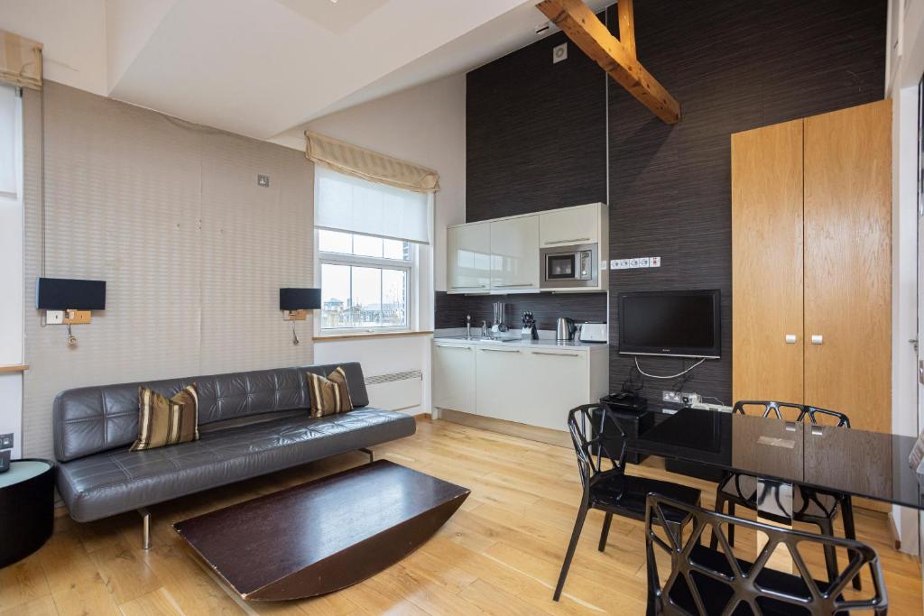 ロンドンにあるスペース アパートホテルのリビングルーム(黒い革張りのソファ、テーブル付)