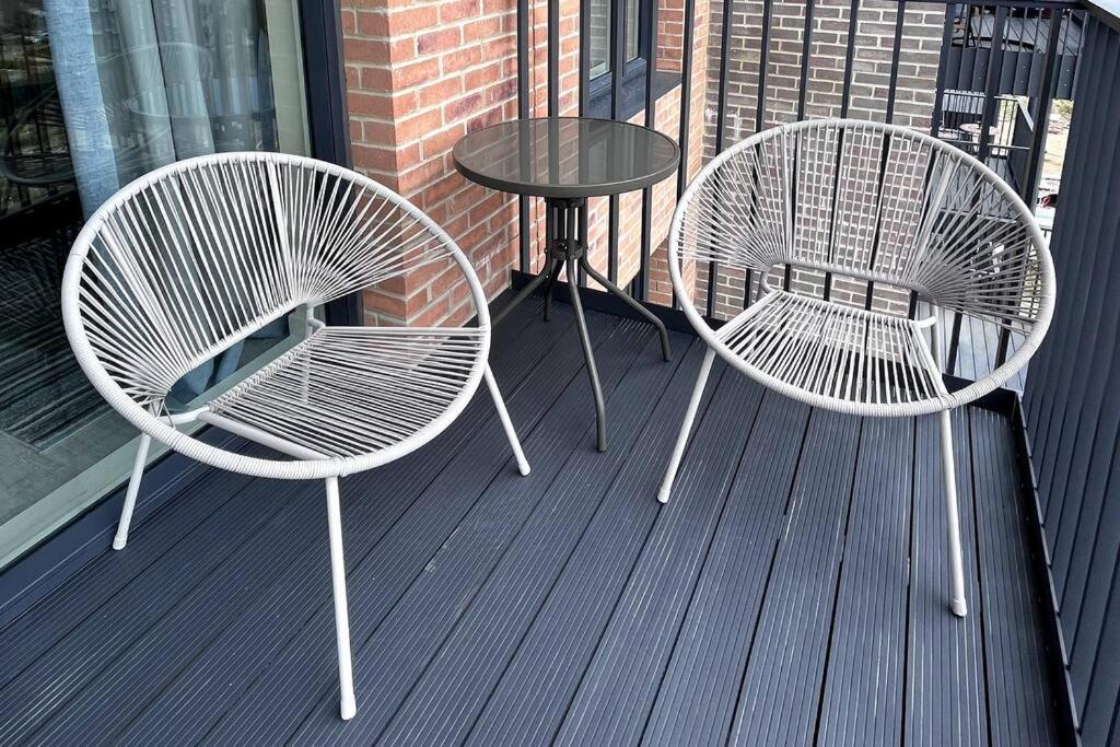 2 Stühle und ein Tisch auf einer Terrasse in der Unterkunft Bright Modern Flat with Balcony 30mins from Euston in Harrow