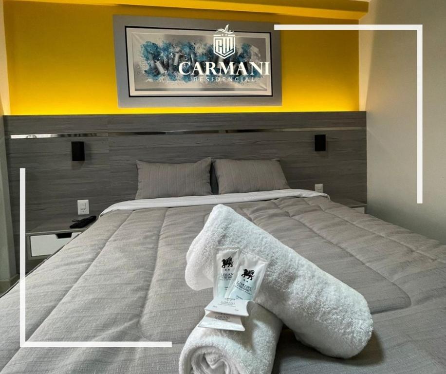 a bedroom with a large bed with towels on it at RESIDENCIAL CARMANI in Tacna